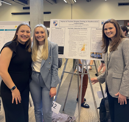 Molly Mullin (L), Alison Cartier, and Juline Horan presenting their data on college students and nuclear weapons as part of a class assignment at Catholic University of America. (Photo by Catholic University of America)